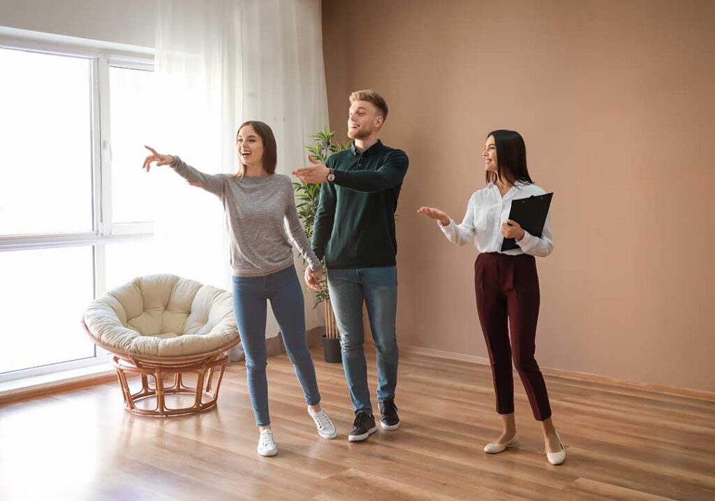 A couple reviews a moving checklist beside labeled boxes and packed household items.