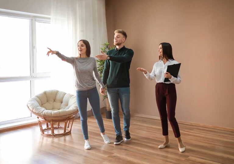 A couple reviews a moving checklist beside labeled boxes and packed household items.